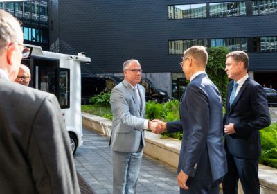 Kaarel Variksaar, board member of Auve Tech, shaking hands with the President of Finland in front of an autonomous shuttle