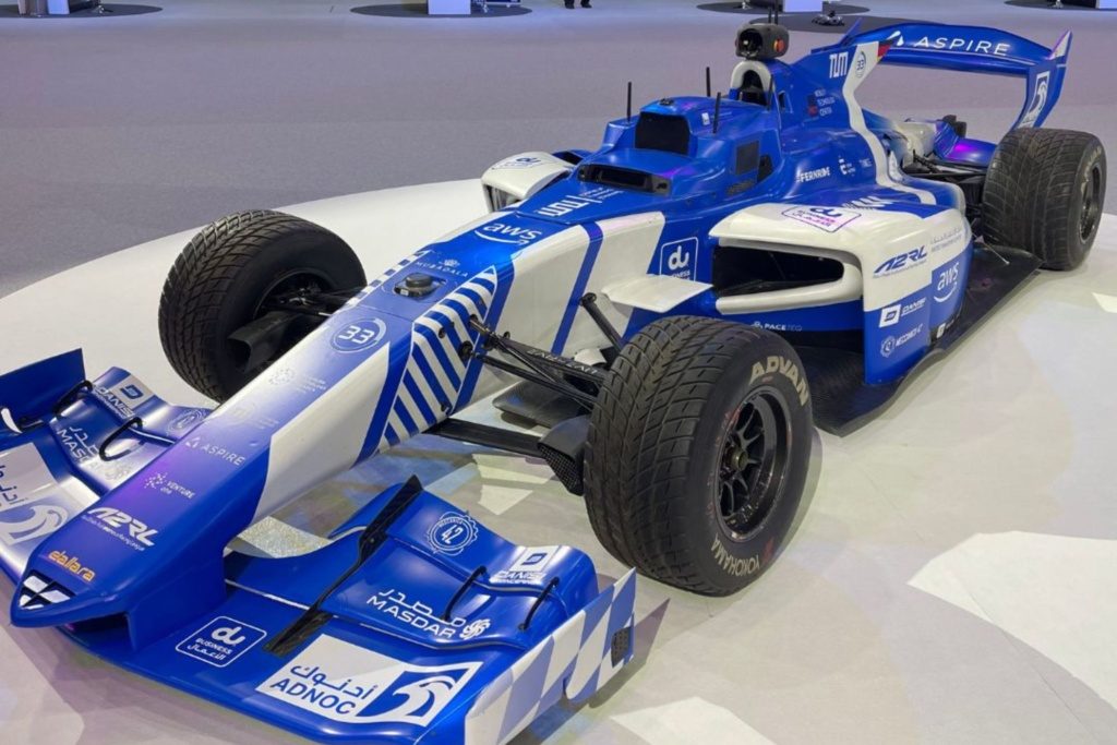 Blue and white Formula car displayed at ITS World Congress 2024 in Dubai, showcasing advanced autonomous racing vehicle technology.